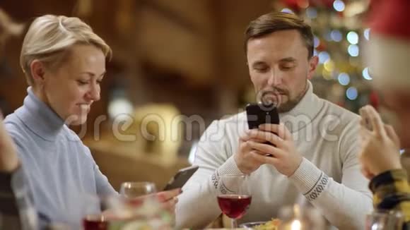 带着手机无聊的圣诞晚餐和一对情侣视频的预览图