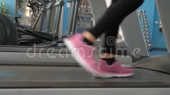体育生活理念穿运动鞋的女孩的腿沿着跑步机走特写镜头加强腿部肌肉视频的预览图