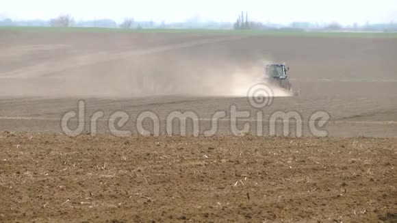 一辆拖拉机在田野里身后有一片尘土视频的预览图