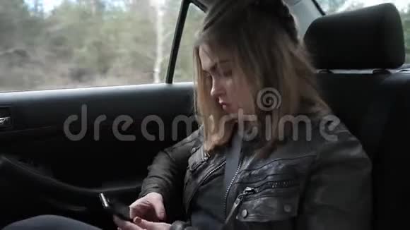 坐在汽车后座上的年轻女子视频的预览图