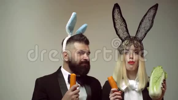 兔子夫妇吃胡萝卜兔子耳朵概念与兔子夫妇活泼的复活节夫妇兔子男女惊喜视频的预览图
