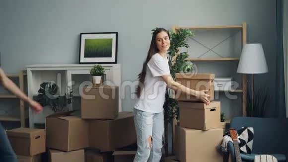 在新公寓搬迁期间女孩和男人把东西装在箱子里视频的预览图