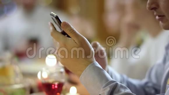 爷爷在家庭圣诞晚餐期间用智能手机上网关门视频的预览图