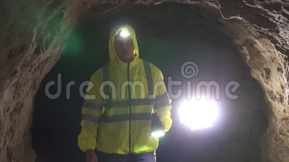 画像男志愿者救援者手里拿着手电筒正在洞穴里寻找一个人慢一点视频的预览图