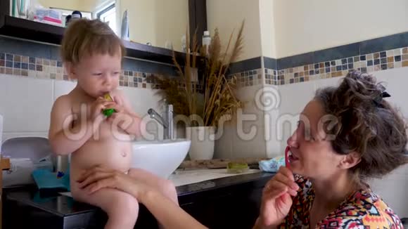 妈妈和孩子在浴室刷牙幸福的家庭观念母亲背景幸福家庭概念视频的预览图