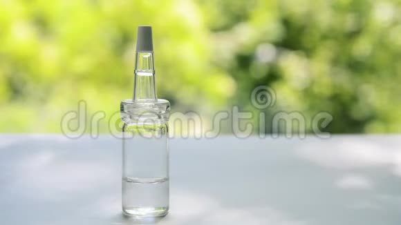 一个装有乳清的吸管的玻璃瓶立在白色的桌子上背景是随风摇曳的树木视频的预览图