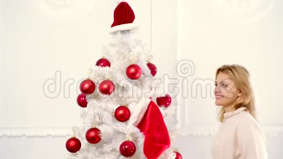 圣诞快乐新年快乐圣诞节庆祝节日用红球装饰圣诞树的女人视频的预览图
