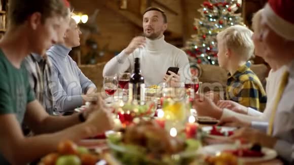 男人在智能手机上做家庭圣诞晚餐的视频翻译视频的预览图