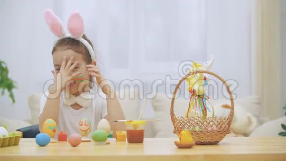 可爱的小女孩真诚地微笑着她拿了一个复活节彩蛋用她的方式展示了她的工作成果视频的预览图