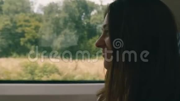 站在火车窗外的一个漂亮的年轻女人旅行运输概念视频的预览图