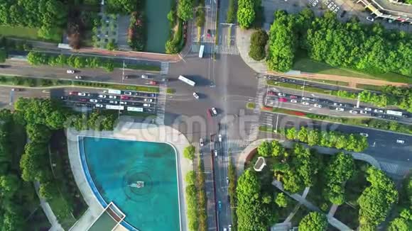 空中无人机在城市的十字路口汽车和公共汽车在大道上行驶日落时分摄像机向下移动视频的预览图