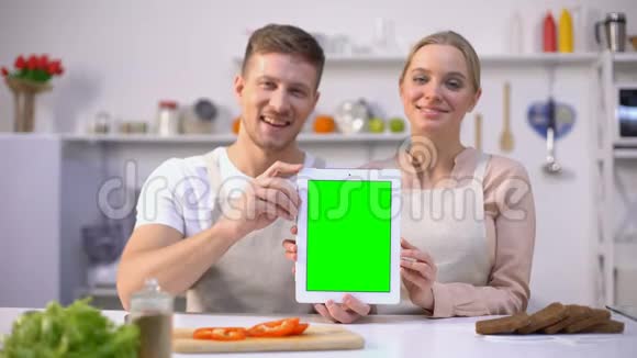一对幸福的情侣手持绿屏平板电脑网上购物模板视频的预览图