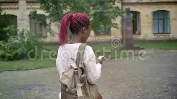 年轻的非洲女人背着背包拿着电话上大学学生带着粉红色的恐惧视频的预览图