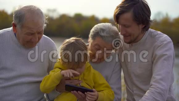 孙孙的慢镜头和他的父亲一起教他的孙孙父母如何使用他的申请视频的预览图