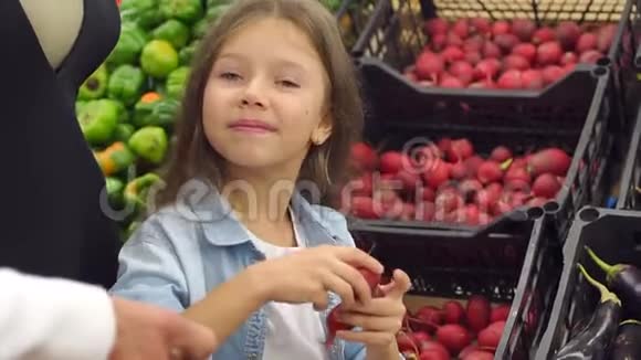 小女孩的特写在超市和父母一起买新鲜萝卜视频的预览图