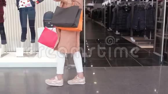 慢动作下半身的年轻女游客带着商店橱窗在购物中心散步散步时经过视频的预览图