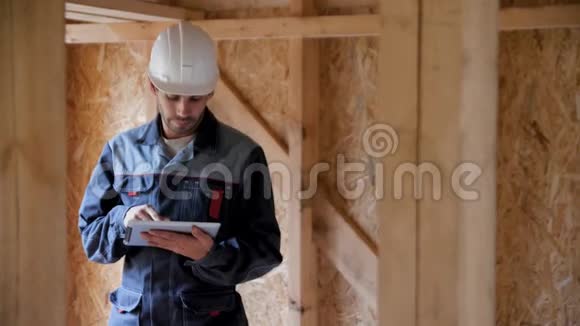 建筑师或建筑商检查半建木框架房屋的计划建筑工地上的微笑建筑工人视频的预览图