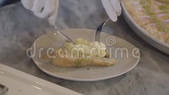 厨师的手在白色橡胶手套准备东方甜库纳法把融化的奶酪在近距离土耳其视频的预览图