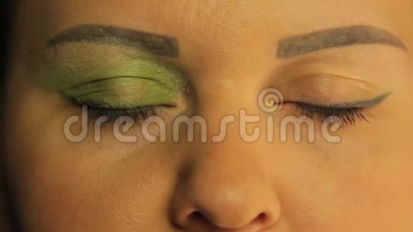 女性的眼睛一只眼睛染上了明亮的绿色阴影视频的预览图