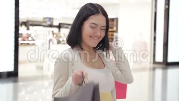 女人去购物中心购物她买了很多东西现在用购物袋旋转视频的预览图