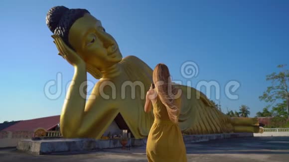 一位年轻的女旅行者带着一尊躺着的佛像参观了WatSrisoonthorn寺拍摄了一张慢镜头视频的预览图
