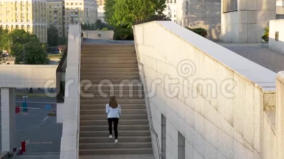 棕色头发的女人爬楼梯视频的预览图