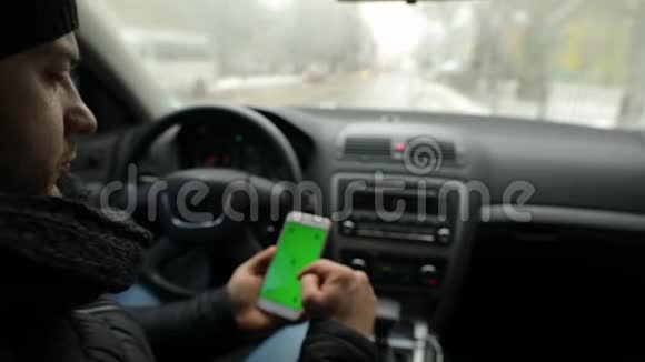男子展示空绿色屏幕智能手机在汽车色度键视频的预览图