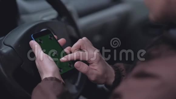 男性司机使用智能手机车里有绿色屏幕视频的预览图