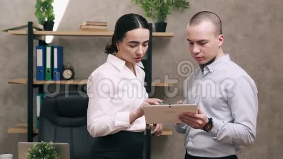 男人和女人看平板电脑屏幕和领导讨论视频的预览图