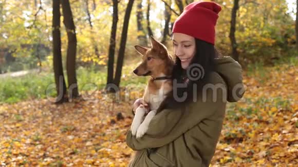 秋日与狗一起微笑嬉戏的女孩视频的预览图