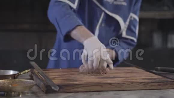 在现代餐厅里一个穿着蓝色厨师制服的熟练男子为卢拉串肉准备生肉大型烤架视频的预览图