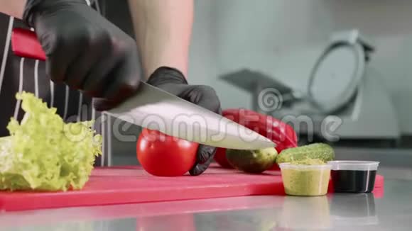 厨师正在切番茄做汉堡双手戴黑色手套特写视频的预览图
