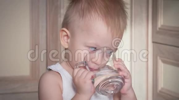 快乐的小男孩在家喝玻璃水关门视频的预览图