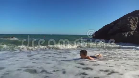男孩夏天在海滩上玩得很开心视频的预览图