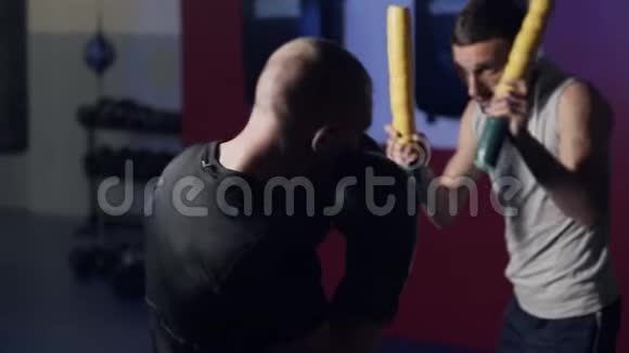 教练训练拳击手在健身房锻炼踢和防守慢动作视频的预览图