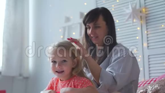 母亲和女儿一边聊天一边梳头视频的预览图