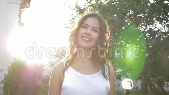 积极的笑女挥舞着头发在户外明亮的太阳能照明中旋转视频的预览图