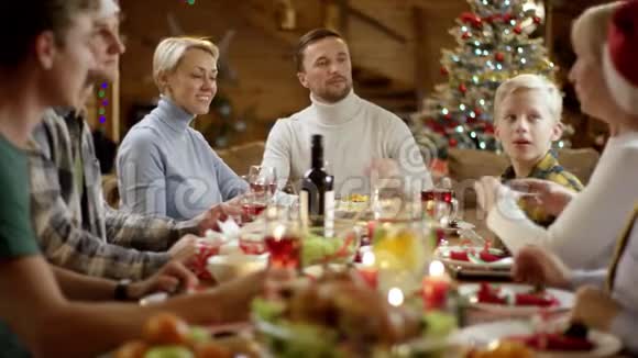 祖母在圣诞餐桌旁为夫妻合影视频的预览图