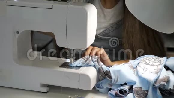 缝衣机上的裁缝工作在布上做直缝双手特写视频的预览图