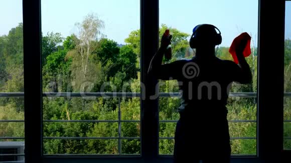 黑暗的轮廓一个男性工人的阴影清洁服务耳机清洁清洗窗户喷涂视频的预览图