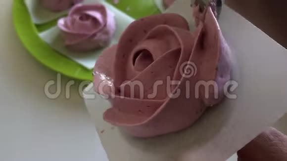 准备棉花糖玫瑰的女人借助展台和糕点包特写视频的预览图