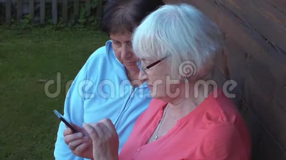 两位关注智能手机的高级女性视频的预览图