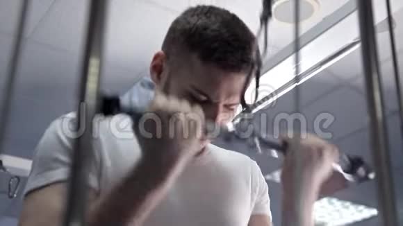 健身房里的男人抖他的三头肌健身器材健身房视频的预览图