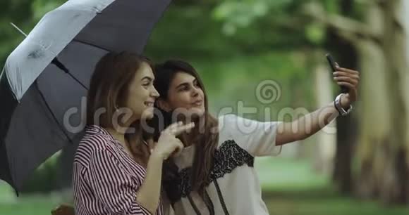 两位女士在一把黑色的伞下自拍视频的预览图