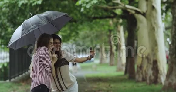 雨天两个女孩在街中央打着伞自拍4公里视频的预览图
