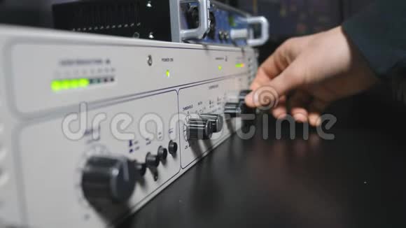 声音工程师的公手启动控制混音器面板上的音量旋钮现代音频编辑器视频的预览图