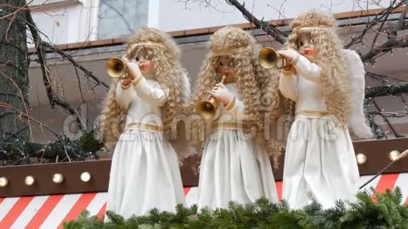 三个移动的天使娃娃他们穿着雪白的裙子在孩子们的圣诞市场的小亭的屋顶上视频的预览图