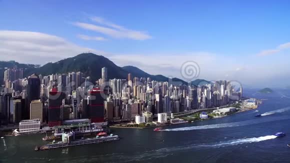 从无人驾驶飞机上拍摄从香港摩天大楼的海面上看船只漂浮在下面视频的预览图