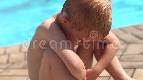 游泳池附近一个悲伤的小男孩的肖像慢节奏视频的预览图