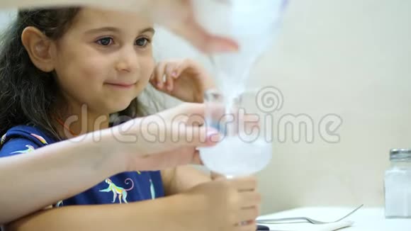 在餐馆里在桌子上小女孩被倒入带有气泡的碳酸矿泉水饮酒视频的预览图